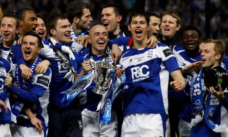Stephen Carr holds the trophy aloft as he celebrates with team-mates after beating Arsenal.