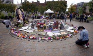 A women kneels in front of a makeshift memorial in honor of Breonna Taylor, at Jefferson Square Park, in Louisville, today.