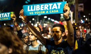 An independence campaigner holds a placard saying ‘Freedom – we want you back home’ at a rally in Barcelona