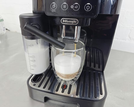 De’Longhi Magnifica Start coffee machine brewing an espresso; its milk carafe is full.