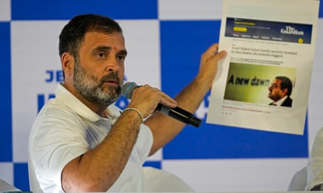 Rahul Gandhi displays a newspaper article about the Adani Group 