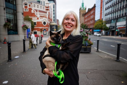 Holly Hennessy smiles holding her Siamese cat Captain on a Belfast street