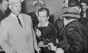 Lee Harvey Oswald is shot by Jack Ruby in a corridor of Dallas police headquarters.