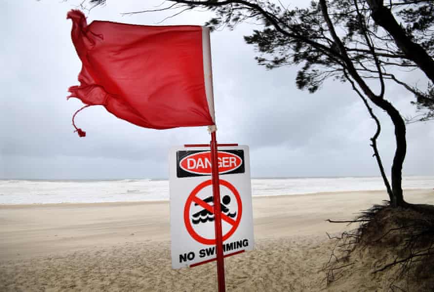 A red flag and a no swimming sign are seen at Southport beach on the Gold Coast on Sunday.