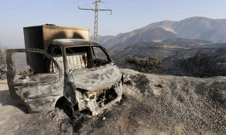 Burnt out truck with barren hills in the background