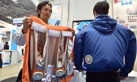 Toru Ichigaya, a Kuchofuku employee, demonstrates an air-conditioned jacket which has cooling fans on its back at the Heat Solutions exhibition in Tokyo in 2015.