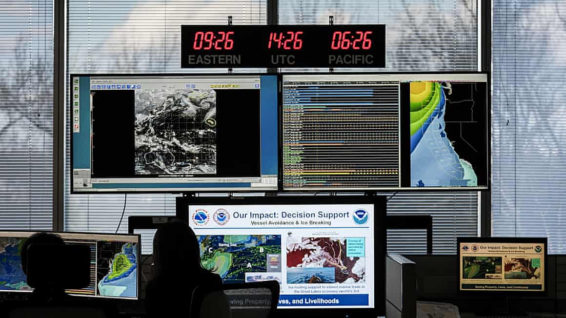 Workers watch monitors at the Noaa Center for Weather and Climate Prediction headquarters.