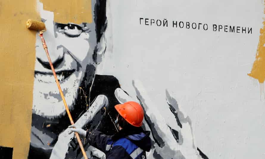 Un muncitor pictează peste o pictură murală care îl înfățișează pe Alexei Navalny în Saint Petersburg în aprilie