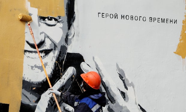 A worker paints over a mural depicting Alexei Navalny in Saint Petersburg in April