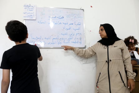 Batool Ghanem teaches one of her pupils using a whiteboard at the Oxygen centre, Shatila refugee camp, Lebanon