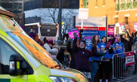 NHS nurses cheer as an ambulance passes the picket outside Leeds General Infirmary