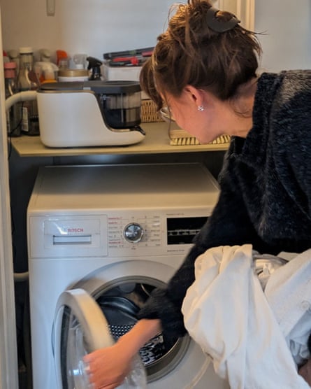 A woman prepares to put a load of washing into a machine