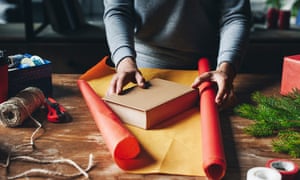 woman wrapping book as christmas giftcropped shot of woman wrapping book in paper as christmas gift