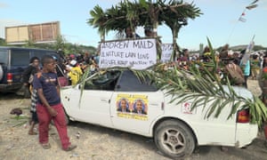 A car is decorated with voting posters at an election rally in the Papua New Guinea capital, Port Moresby.