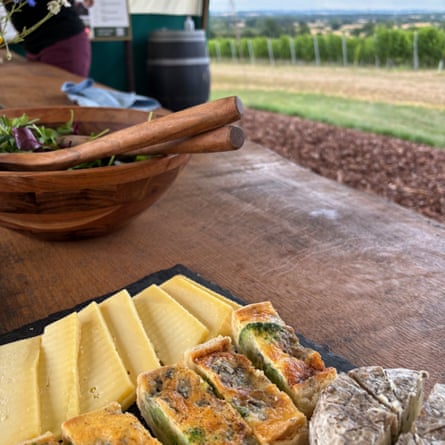 View of the Herefordshire countryside from an outdoor table stocked with cheese, quiche, bread and salad.