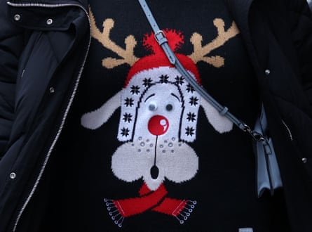 A shopper wears a Christmas jumper as she walks past the shops on Oxford Street in central London in December 2022