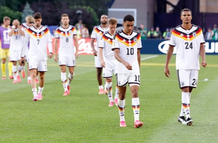 Jamal Musiala, left, and Malick Thiaw of Germany and teammates leave the filed dejected after their defeat.