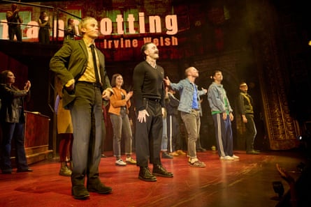 Five men on a red stage, with the words ‘Trainspotting Irvine Welsh’ in the background