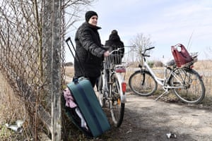 A woman waits for her relatives to pick her up at the Hungarian-Ukrainian border, in Barabas, Hungary