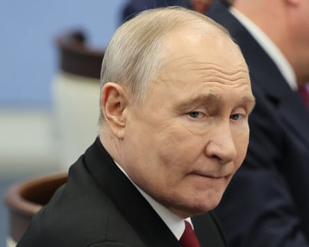 Close-up of Vladimir Putin, who is looking downwards