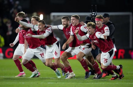 Fleetwood Town players run across the pitch celebrating a penalty shootout win