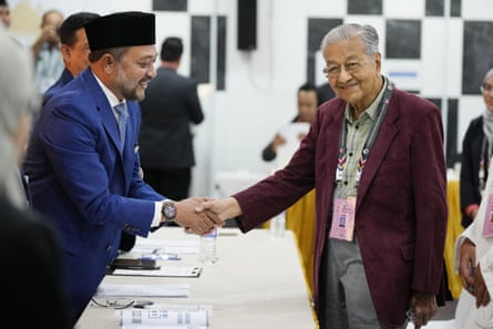 Mahathir is greeted by a nomination official after submitting his nomination documents