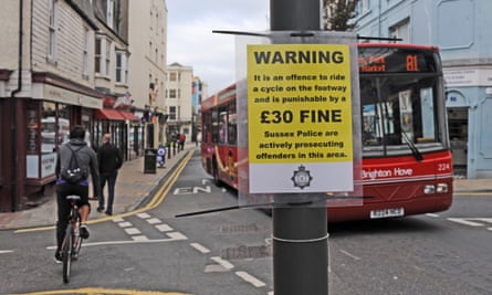 A sign warns cyclists of a £30 fine for cycling on the pavement in St James’s Street, Brighton.