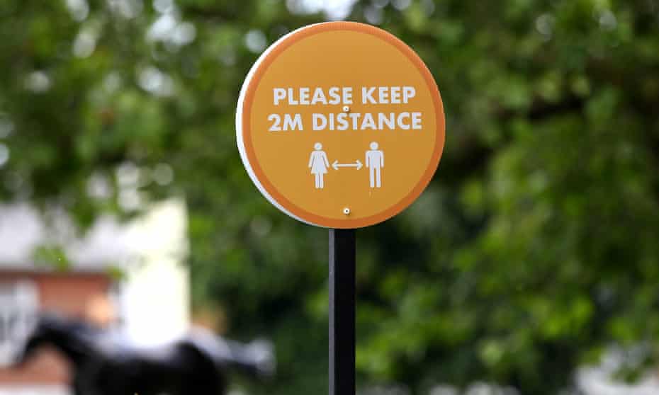 A sign reminds people to maintain the 2-metre distance on day one of the Royal Ascot horse racing meet
