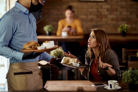 Woman argues with a server holding plates of food