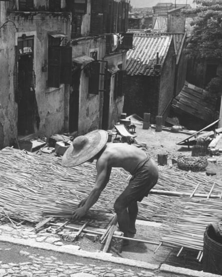 A man lays out incense sticks out to dry in the sun in 1957