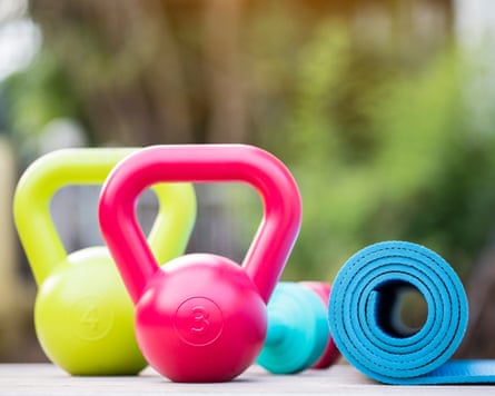 Kettlebell, dumbbell and yoga mat on wood table