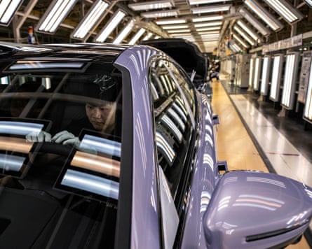A worker checks a finished vehicle on the production line for electric vehicle maker Zeekr