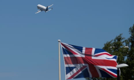 an airbus plane takes off with a union flag in the background