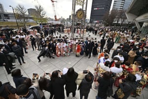 Young adults wearing masks attend a ceremony as they commemorate coming of age day in Tokyo, Japan