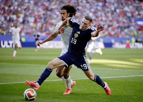 Lewis Ferguson holds off Morocco's Ayyoub Bouaddi.