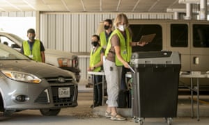 Barbara Cull deposits a ballot in the ballot box at a drive-through drop off location in Austin, Texas, on 1 October.