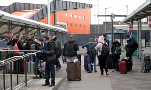 New arrivals queue for a bus at Luton Airport.