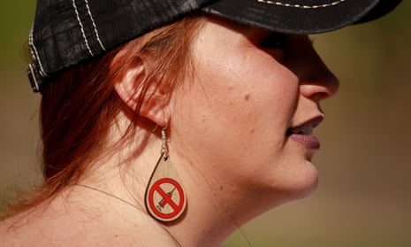 A protester wearing anti-vaccination earrings takes part during the demonstration in Indianapolis