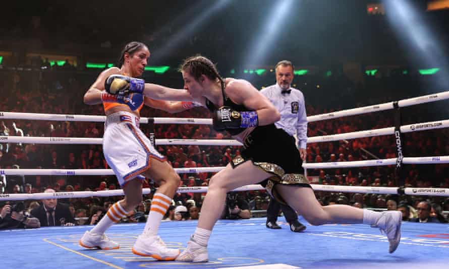 Katie Taylor lands a right-handed punch in her fight against Amanda Serrano, who moves to her left to avoid it.