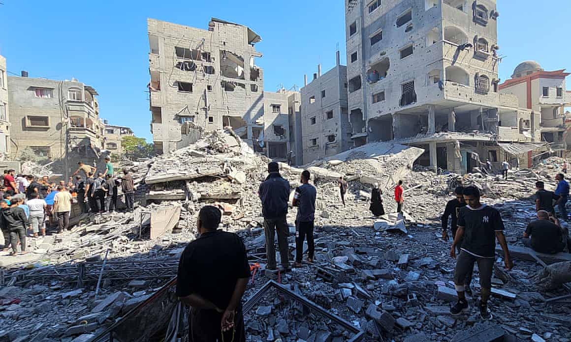 People walk among rubble in aftermath of Israeli strikes on houses and residential buildings