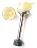 A stick blender covered with mayonnaise and a bowl of mayonnaise