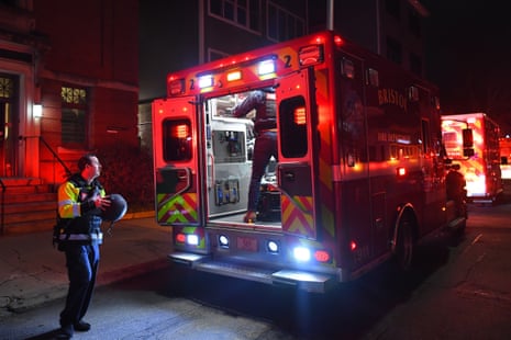 Emergency personnel step out of a vehicle at night