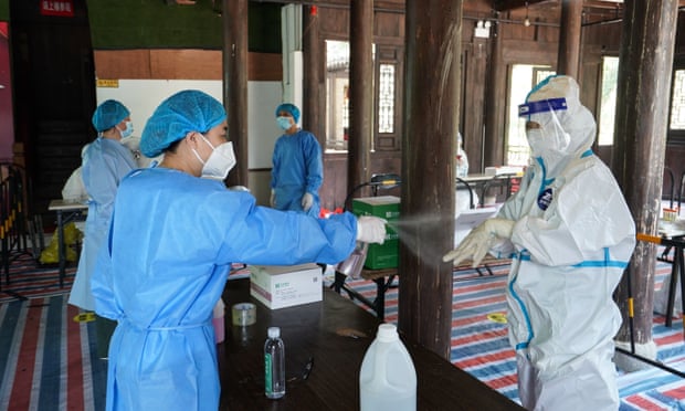 Staff disinfect themselves at a testing site in Nanjing