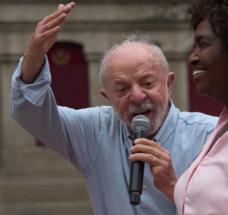Lula speaking into a microphone with his hand in the air