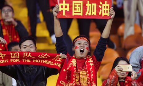 Fans cheer before the match between China and Syria. The Chinese characters read, ‘China fighting’