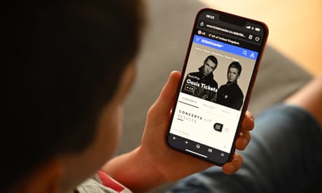 A fan uses a smartphone to buy Oasis tickets online