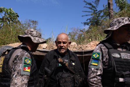 Nilton Tubino and two members of special forces stand outside a bunker