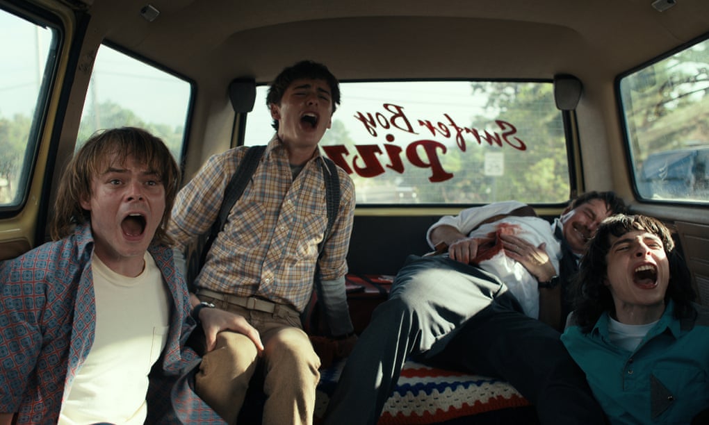 Charlie Heaton, Noah Schnapp and Finn Wolfhard howl in the back of a station wagon in season 4 of Stranger Things.