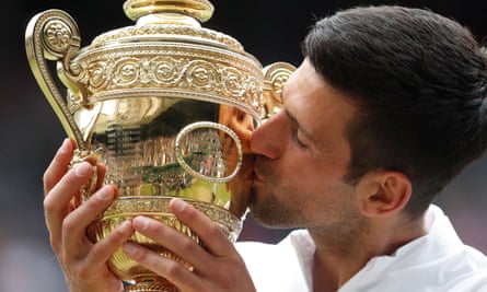 Novak Djokovic kisses the Wimbledon trophy after winning it in 2021