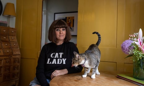 Dawn O’Porter sitting at her kitchen table with her cat Boo on it near her